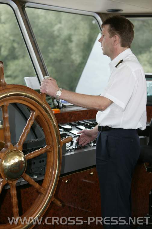 05.08.24_127 Käpt'n Reisinger mit linker Hand auf Riesensteuerrad, das allerdings nur noch Deko-Funktion hat, das Schiff steuert er mit seiner Rechten mittels Minijoystick.