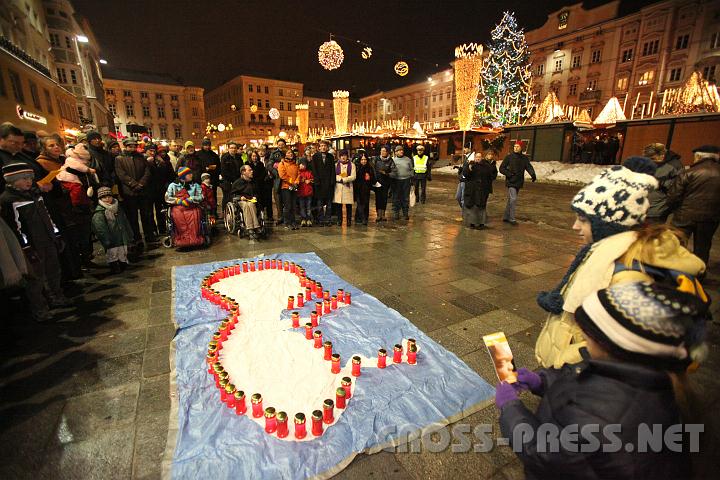 2010.12.04_18.01.48.jpg - Am Hauptplatz gegenüber dem Adventmarkt formten die Teilnehmer, darunter viele Kinder, mit ihren Kerzen einen Embryo.